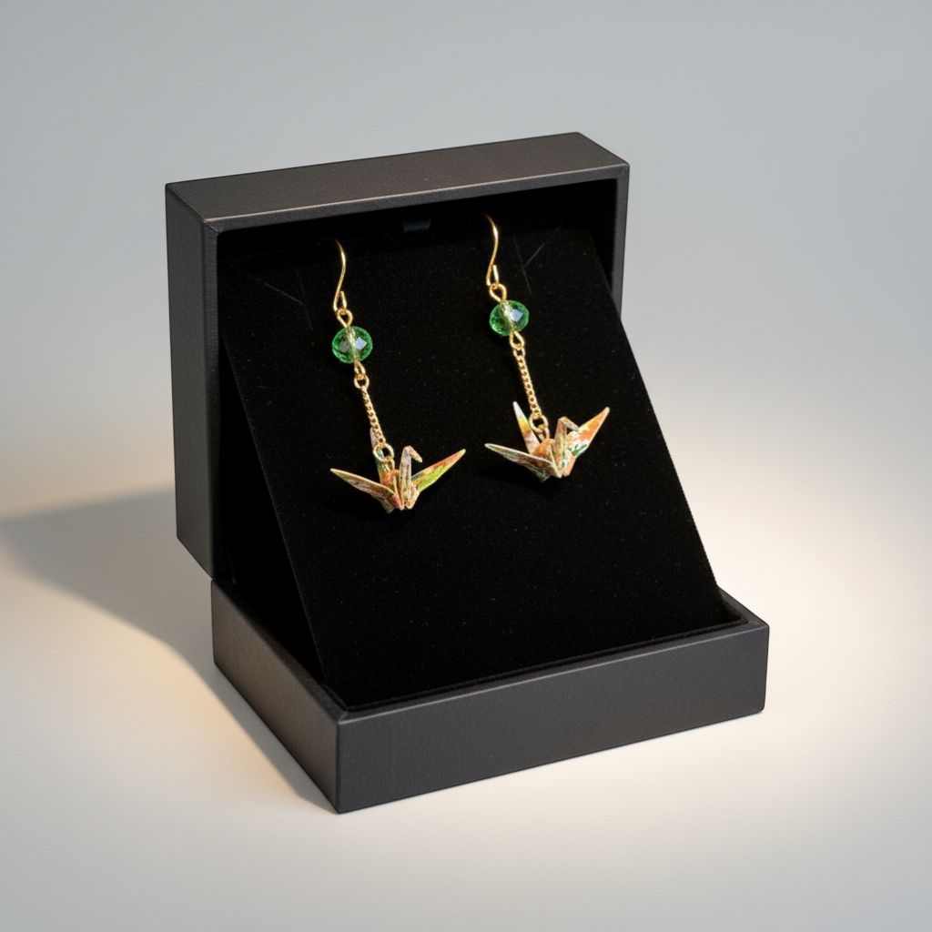 Butter Moon Creations, LLCHandmade Japanese Washi paper origami crane earrings with green crystal accents and gold-plated dangles.